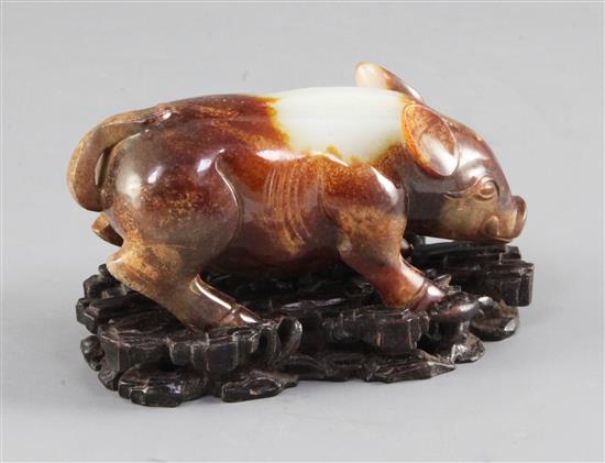 A Chinese archaistic white and brown jade figure of a standing pig, 9.6cm, with carved wood stand and fitted box